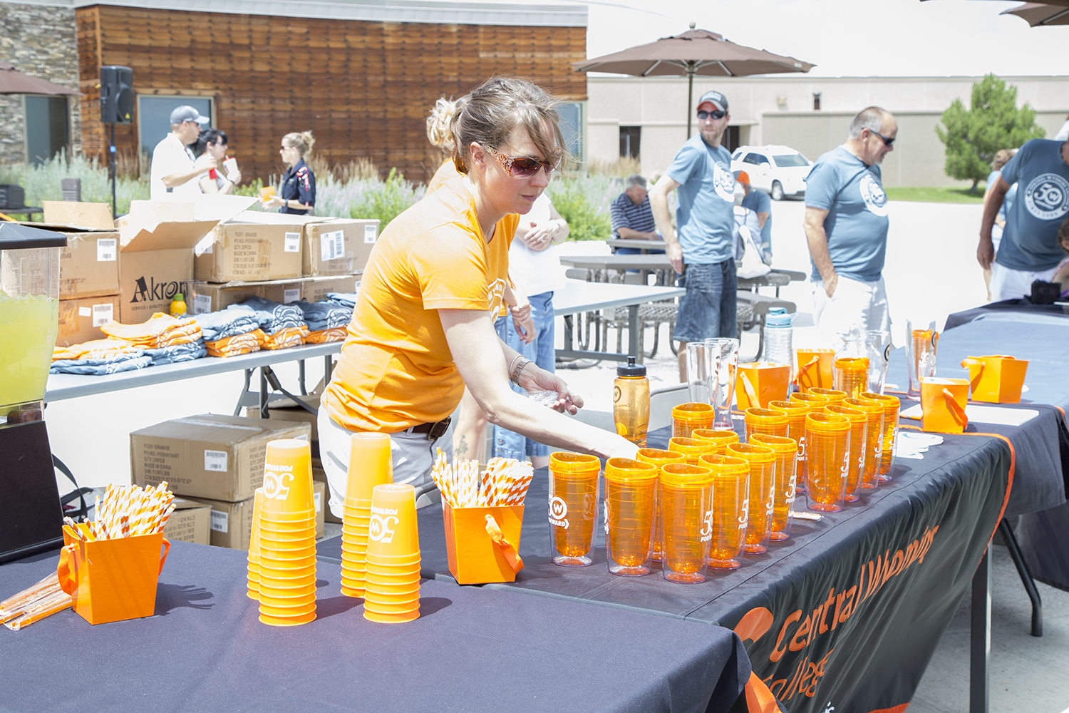 Woman setting up a table of orange CWC cups