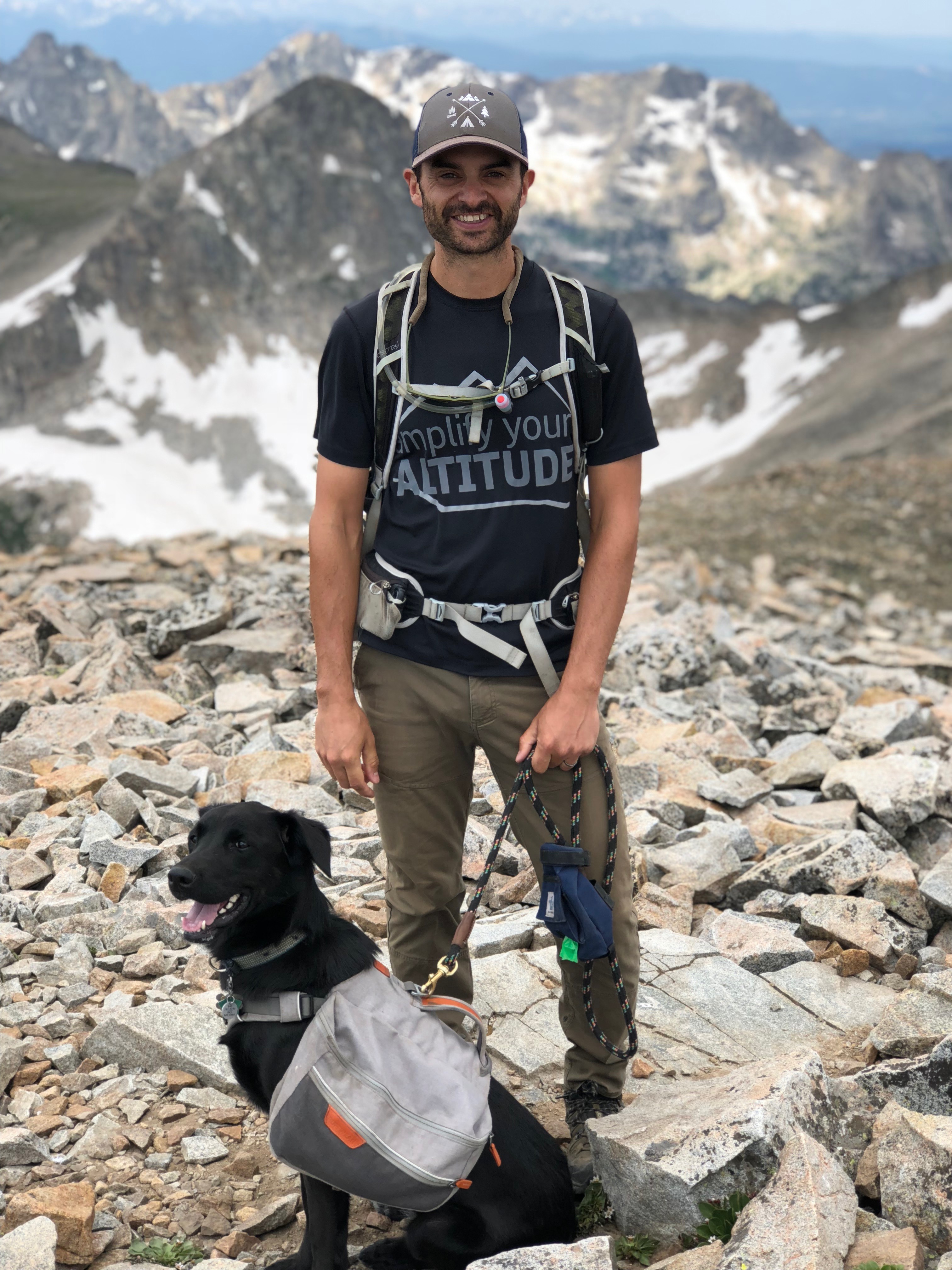 photo of Ethan Page and his black lab dog hiking in the mountains