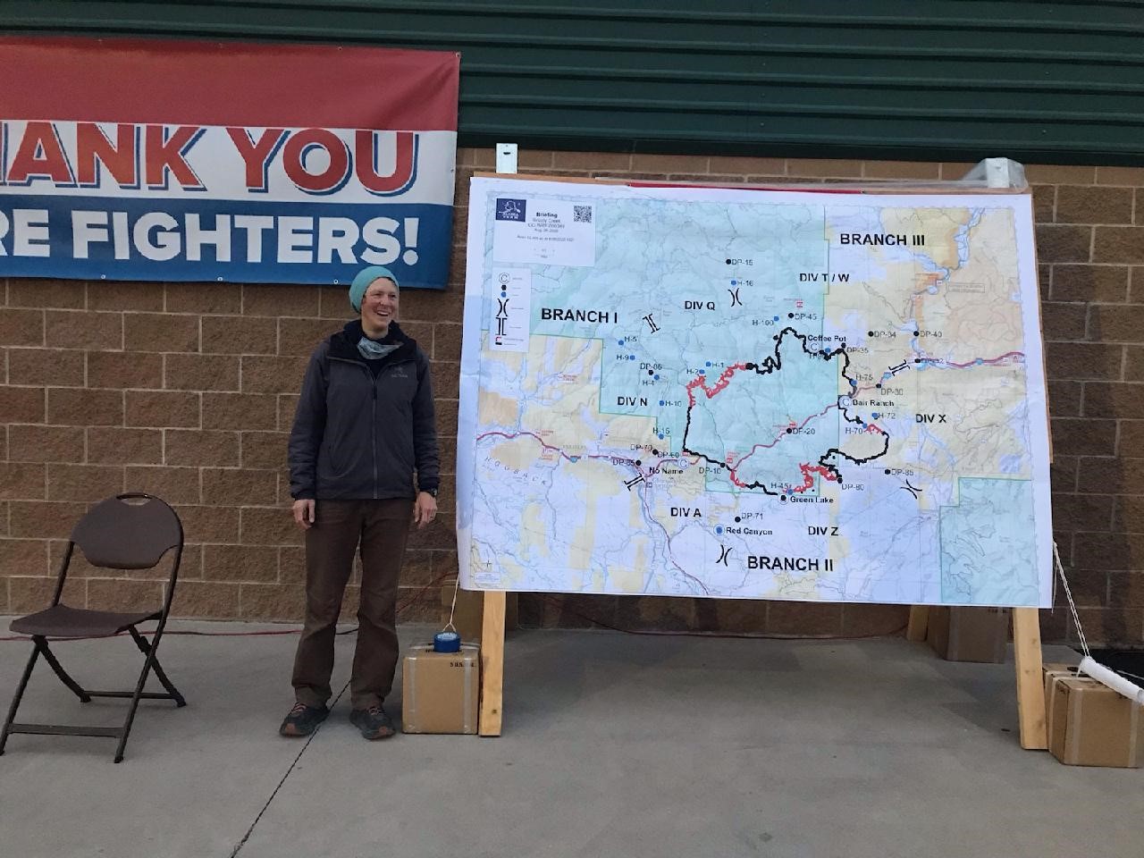 Sarah Strehle stands next to a map she uses for mapping fires with GIST