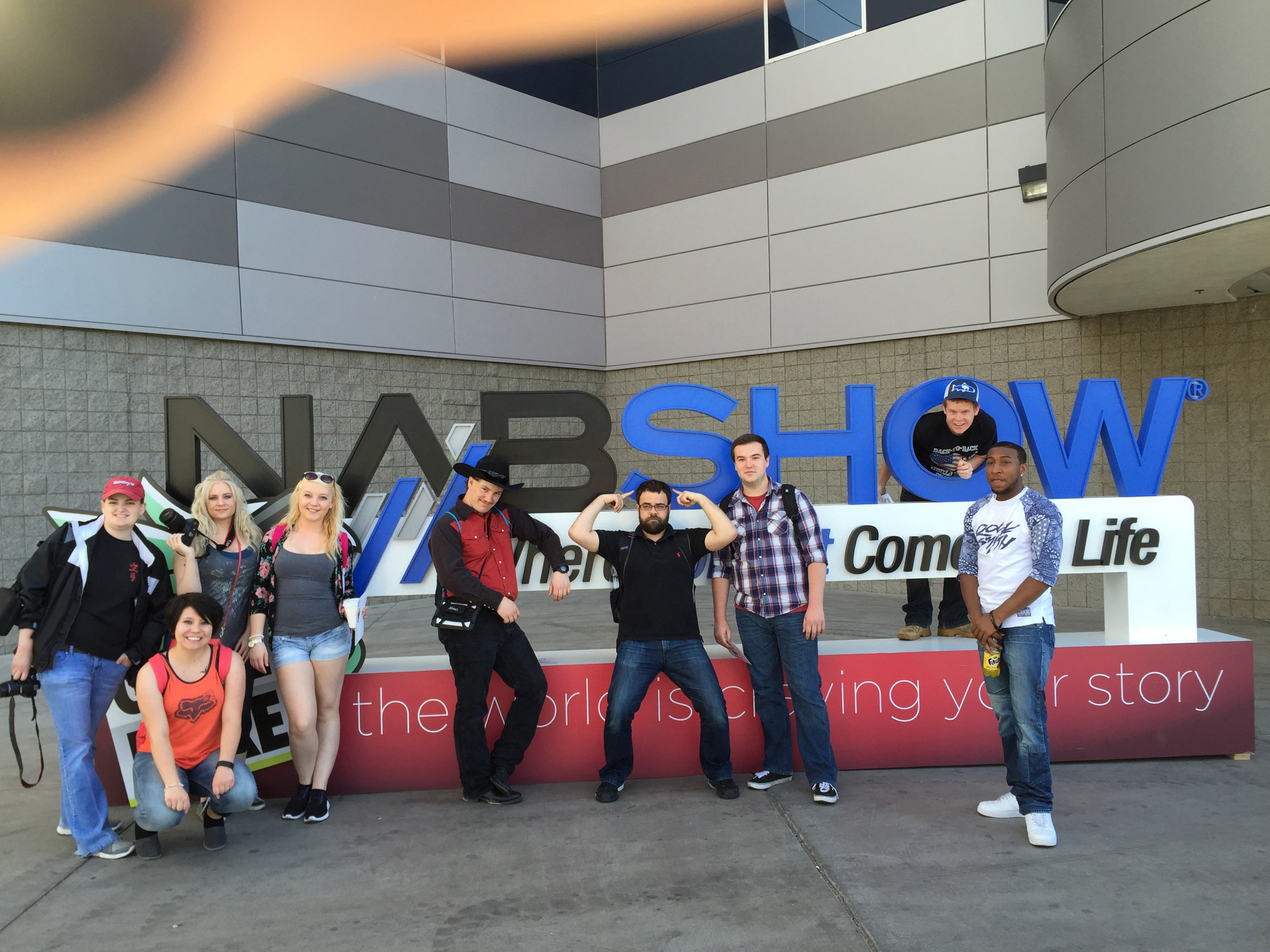 photo of Central Wyoming College students in front of the NAB show sign in Las Vegas during the NAB conference 2015