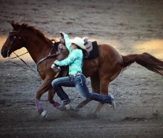 rodeo contestant jumping off her horse